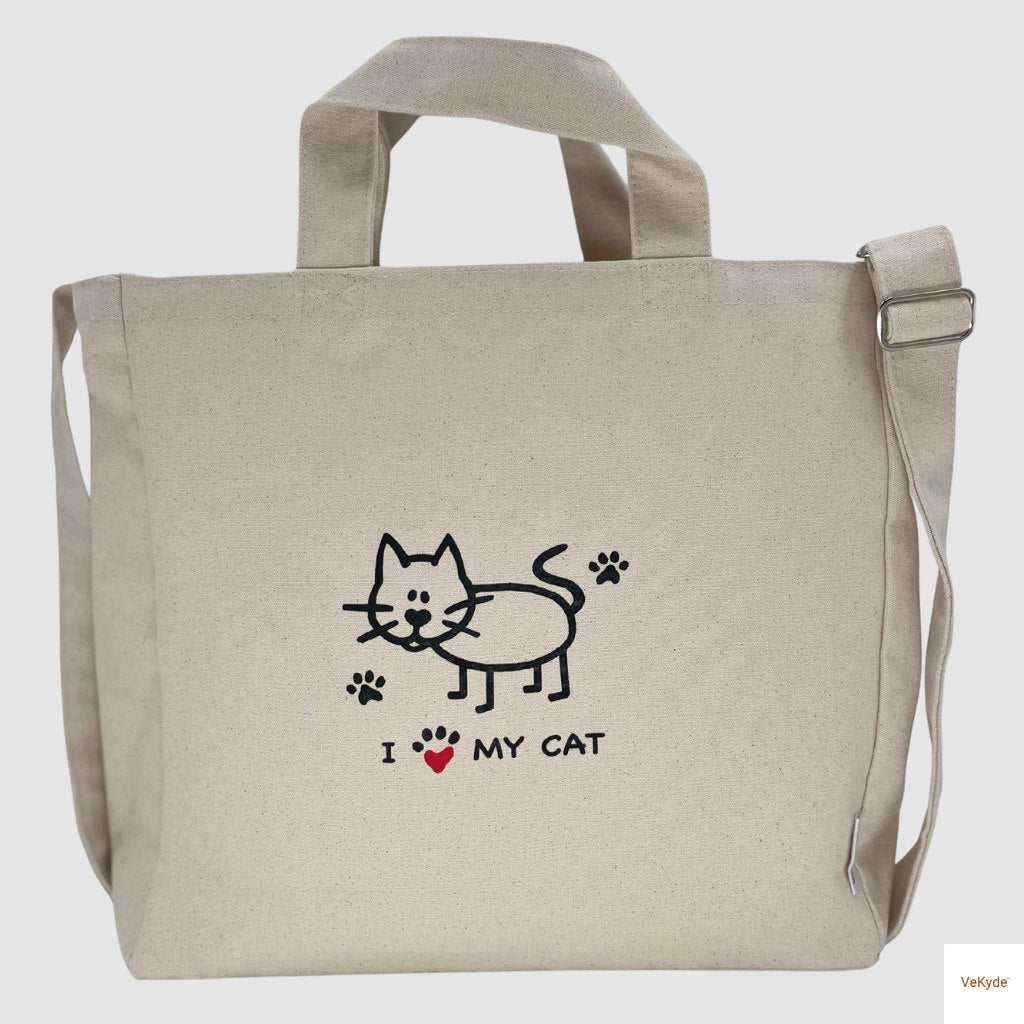 Natural cotton canvas crossbody bag with adjustable strap, featuring a cute “I Love My Cat” print with paw prints and cartoon cat design